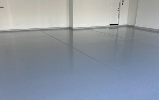 AZ Garage Floors technician performing adhesion testing after epoxy base. Click to request a warranty-backed installation quote.