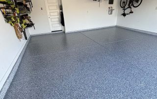 Final topcoat application in progress on a residential garage floor by AZ Garage Floors. Click to schedule your installation and get a timeframe.